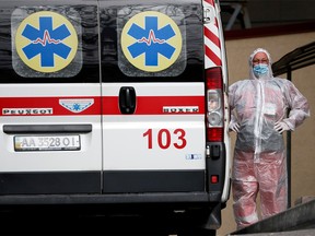 FILE PHOTO: A health worker stands near an ambulance carrying a COVID-19 patient, as they wait in the queue at a hospital for people infected with the coronavirus disease in Kyiv, Ukraine October 18, 2021.