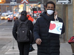 A shopper wearing a mask walks along 4th Street S.W. on Friday, Nov. 5, 2021.
