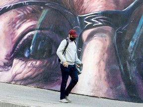 A person wearing a mask walks along an underpass on Macleod Trail S.W. Friday, Nov. 5, 2021.