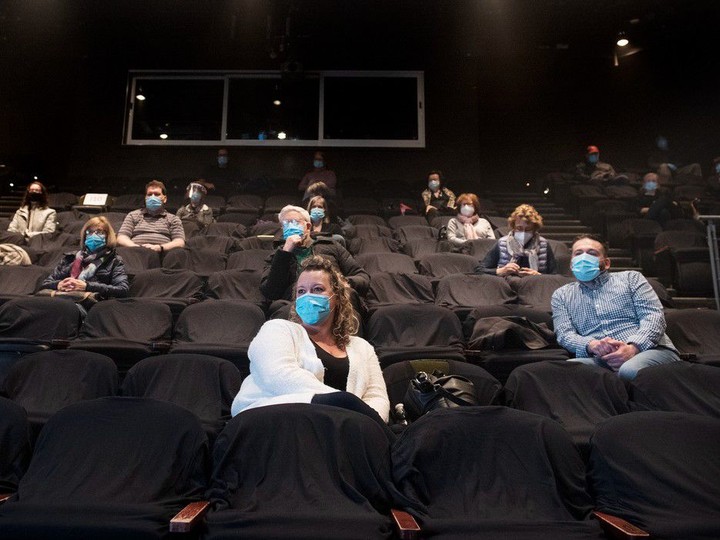  People wear face masks as they wait for the start of a performance at the Centaur Theatre in Montreal on March 28, 2021. Still-hurting theatres, casinos and gyms would be eligible for the new pandemic aid program proposed by the Liberals