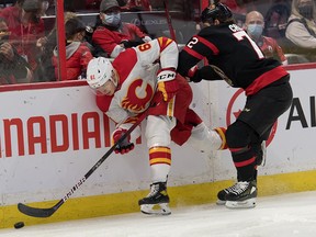 Calgary Flames right winger Walker Duehr evades a check by Ottawa Senators defenceman Thomas Chabot at the Canadian Tire Centre in Ottawa on Nov. 14, 2021.