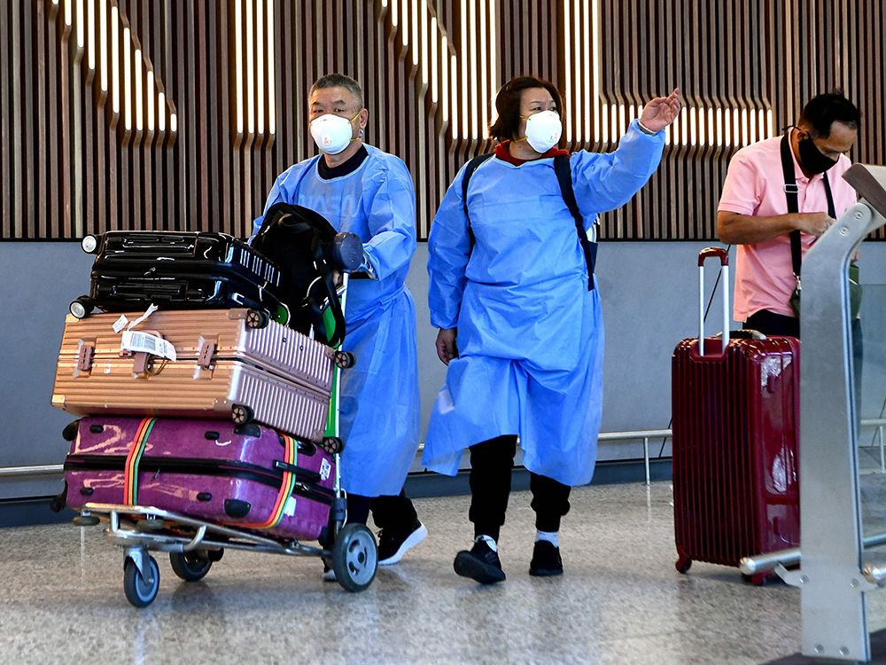  International travellers wearing personal protective equipment arrive at Melbourne’s Tullamarine Airport on Nov. 29, 2021, as Australia records its first cases of the Omicron variant of COVID-19.