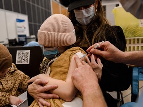 A seven-year-old child receives a Pfizer-BioNTech COVID-19 vaccination in Montreal on Wednesday, Nov. 24, 2021.