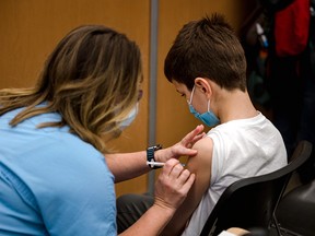 An 11-year-old boy receives a Pfizer-BioNTech COVID-19 vaccine in Montreal on Nov. 24, 2021.