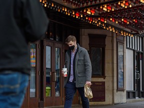 A masked pedestrian walks along Stephen Avenue in downtown Calgary on Tuesday, Nov. 9, 2021.