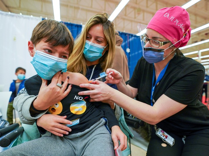  Dean Eliaz is comforted by his mom Michelle Eliaz as he gets his COVID-19 shot at a Humber River Hospital vaccination clinic in Toronto on Thursday.