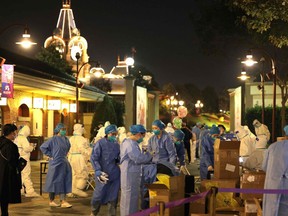 This photo taken on October 31, 2021 shows medical personnel preparing to test visitors for the Covid-19 coronavirus at Disneyland in Shanghai after a single coronavirus case was detected at the park on the weekend.