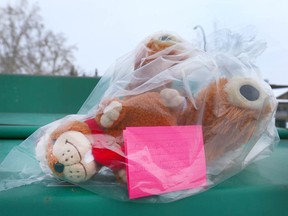 Stuffed animals wrapped in plastic, accompanied by a note, are left near a bin where a newborn was found deceased in Bowness on Christmas Eve, 2017.