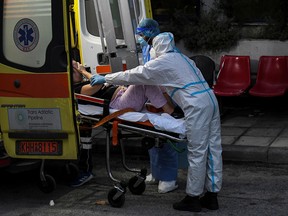 Medical workers wearing personal protective equipment tend to a patient at a COVID-19 ward of the Ippokrateio General Hospital in Thessaloniki, Greece, Nov. 3, 2021.