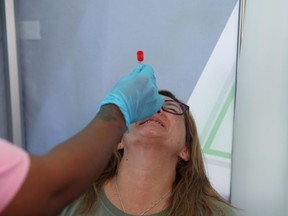 A healthcare worker collects a swab from Bronwen Cook for a PCR test against the coronavirus disease (COVID-19) before traveling to London, at O.R. Tambo International Airport in Johannesburg, South Africa, November 26, 2021. REUTERS/ Sumaya Hisham