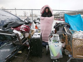 John Malcolm pokes his head out of sleeping bag at an encampment at the Drop in Centre on Tuesday, November 23, 2021.