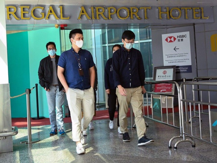  People leave the Regal Airport Hotel at Chek Lap Kok airport in Hong Kong on Nov. 26, 2021.