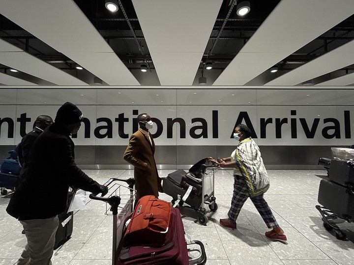  International passengers walk through the arrivals area at Heathrow Airport on Friday in London, England.