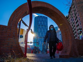 A masked pedestrian walks through Calgary’s Chinatown on Wednesday, Nov. 24, 2021.