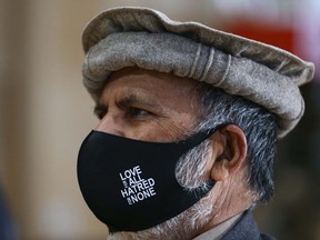 An attendee shares a message on his mask during ceremonies as Calgary Muslims observe Remembrance Day at Baitun Nur Mosque on Friday, Nov. 12, 2021.