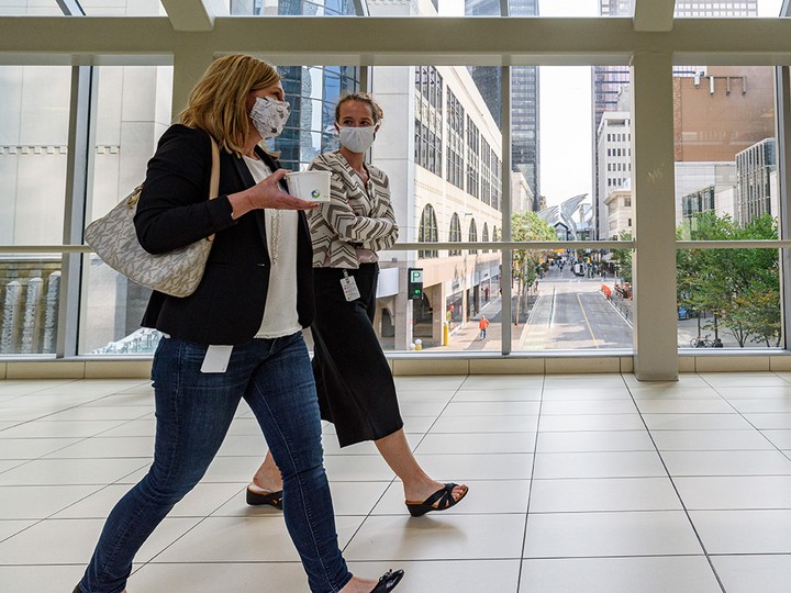  People wearing masks walk through the Plus-15 in downtown Calgary on Sept. 8, 2021.