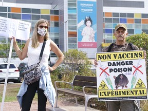 An anti-vaccine protester and a vaccine supporter demonstrate in front of a hospital in Montreal on Sept. 13, 2021.
