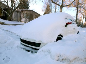 A car is nearly buried in snow on Northmount Drive N.W. after a storm in late December 2020.