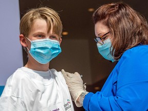 Charles Muro, 13, is given a COVID-19 vaccine at a vaccination centre in Hartford, Connecticut. Canada is expected to approve vaccinations for children age five to 11 on Friday, Nov. 19, 2021.