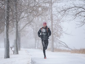 A jogger braves the cold and the snowfall to go for a run along the Bow River on Wednesday, December 8, 2021.