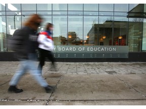 Pedestrians pass by the Calgary Board of Education building is shown In downtown Calgary on Tuesday, December 7, 2021.