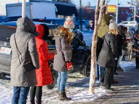People brave the cold to line up for free COVID-19 rapid test kits at the Shoppers Drug Mart in Kensington on Friday, Dec. 17, 2021.