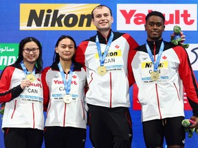 From left, Canada’s Margaret Mac Neil, Kayla Sanchez, Yuri Kisil and Josh Liendo celebrate victory in the 4x50-metre mixed relay during the FINA World Swimming Championships at Etihad Arena in Abu Dhabi on Friday, Dec. 17, 2021.
