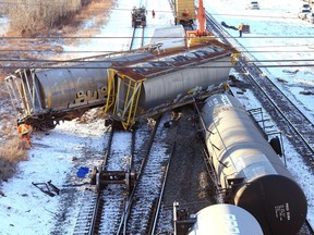 Workers clear a train derailment at Ogden Rd and 50 Ave SE in Calgary on Saturday, December 11, 2021. There were no injuries and no dangerous goods leaked or spilled in the incident which happened about 3:45 a.m.