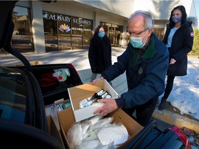 Calgary Seniors' Resource Society volunteers and staff load their cars with supplies to deliver items to seniors in need.
Gavin Young/Postmedia