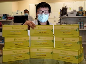 Roy Li, a pharmacist at Market Drugs Medical Ltd. in downtown Edmonton, displays some COVID-19 rapid antigen test kits that were still available at the pharmacy on Tuesday, Dec. 28, 2021.