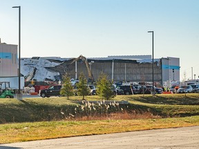 An excavator removes debris from a collapsed roof at an Amazon warehouse following a tornado in Edwardsville, Illinois, U.S., on Sunday, Dec. 12, 2021. Tornadoes ripped across several U.S. states late Friday, killing at least six at a Amazon warehouse that was partially flattened in Illinois.