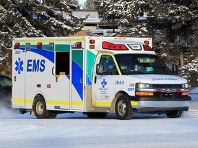 An ambulance sits idling outside a home along Bonaventure Dr. SE. Wednesday, December 29, 2021.