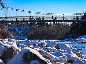 A runner crosses the bridge over the Elbow River towards Riverdale Park on a cool morning in Calgary, Thursday, December 9, 2021.