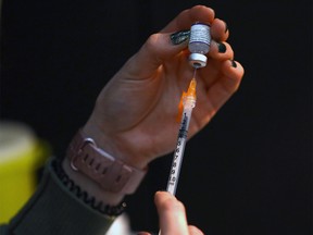 A nurse prepares a COVID-19 vaccination at a mobile clinic in Calgary on Dec. 21, 2021.