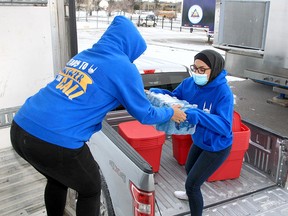 Layla Charanek and Kohawar Khan load bottled water onto an 18-wheeler Friday, Dec. 10, 2021. Islamic Relief Canada is collecting donated goods for victims of floods in B.C.