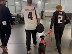 Frisbee Rob McLeod and Sailor the Touchdown Dog walk through the halls in Mercedes-Benz Stadium alongside some stadium employees in Atlanta, GA on Dec. 5, 2021.