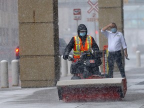 Downtown Calgary got a blast of snow sending commuters and maintence workers scrambling in Calgary on Wednesday, December 8, 2021.
