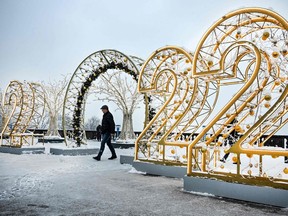 A man walks past large numbers for the upcoming year 2022, as part of Christmas and New Year decorations at Vorobyovy Hills observation point in Moscow on December 15, 2021.