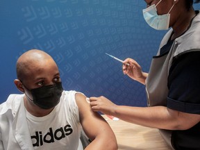 A man receives a dose of the Pfizer/BioNTech vaccine against COVID-19 at Discovery vaccination site in Sandton, Johannesburg, on December 15, 2021. Two shots of Pfizer's Covid vaccine offers around 70 percent protection against severe disease from Omicron, according to results of a study published December 14, 2021 in South Africa.