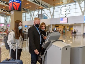 A family checks in for their flight to the United States at Calgary International Airport on Thursday, Dec. 2, 2021.