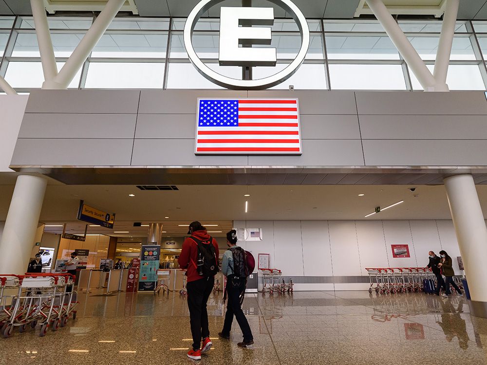  Passengers proceed to enter Gate E in Calgary International Airport for flights to the United States on Thursday.