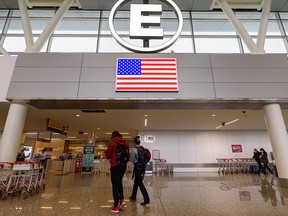 Passengers proceed to enter Gate E in Calgary International Airport for flights to the United States on Thursday, Dec. 2, 2021.