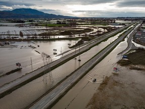 A motorist drives on a service road along the partially flooded Trans-Canada Highway near Abbotsford, B.C., on Dec. 1, 2021. The highway reopened on Thursday, Dec. 2.