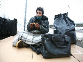 James Andrews peels an orange as he sits outside the Drop in Centre on Nov. 23, 2021.