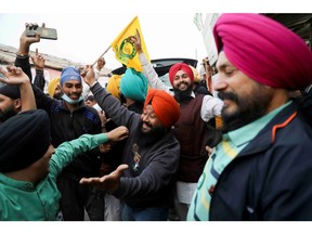 Farmers celebrate after Prime Minister Narendra Modi announced that he will repeal the controversial farm laws, at the Singhu border farmers protest site near Delhi-Haryana border, India, November 19, 2021.