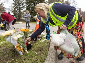 A woman places more flowers Wednesday on the growing memorial to an eight-year-old girl killed by a vehicle on Nov. 30 in London, Ont.