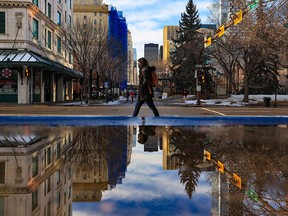 A pedestrian walks past City Hall in Calgary on Friday, Dec. 3, 2021.