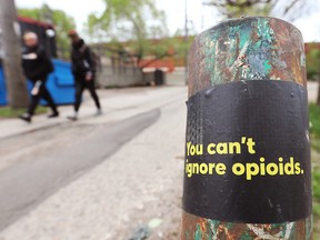 A sticker raises awareness about opioids in an alley near 81st Avenue and Calgary Trail in Edmonton on May 28, 2021.