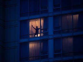 A person stands in the window in a room at a government-authorized COVID-19 quarantine hotel in Richmond, B.C. on Sunday, Feb. 28, 2021.