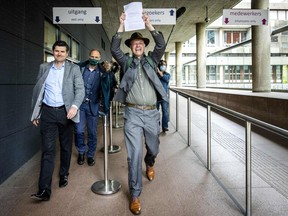 Lawyer Roger Cox, left, and Director of Dutch environment organisation 'Milieudefensie' Donald Pols react as they walk outside a court in The Hague on May 26, 2021, after the district court ruled that Anglo-Dutch multi-national Shell must reduce its emissions by 45 per cent by 2030.